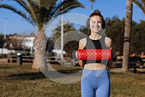 Sport and fitness with equipment, roll outdoor. Sportive athletic young female fitness coach in sportswear and