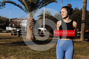 Sport and fitness with equipment, roll outdoor. Sportive athletic young female fitness coach in sportswear and