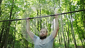 Sport, fitness, exercising people concept. Man doing pull-ups on horizontal bar