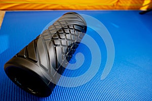 Sport fitness foam roller on blue mat