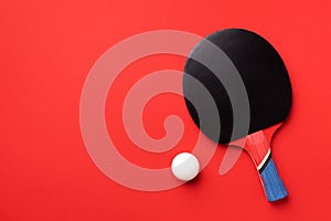 Sport, fitness, healthy lifestyle concept. Ping-pong or table tennis rackets and white ball on red background. Top view. Flat lay