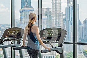 Sport, fitness, lifestyle, technology and people concept - woman exercising on treadmill in gym against the background