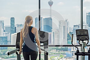 Sport, fitness, lifestyle, technology and people concept - woman exercising on treadmill in gym against the background