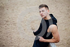 Sport fitness man posing on the beach. Male athlete outside fall park