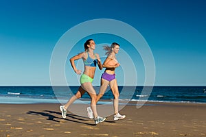 Sport and Fitness - people jogging on beach