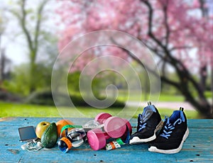 sport and fitness in spring and summer, with sport equipment,waterbottle,dumbbells,measuring tape,smart phone and fruit