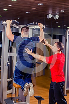 Sport, fitness, teamwork, bodybuilding people concept - man and personal trainer with barbell weight lifting group