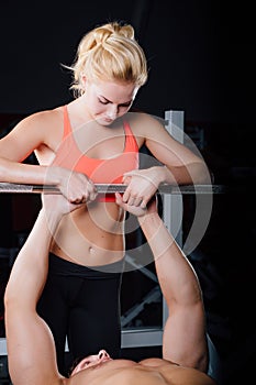 Sport, fitness, teamwork, weightlifting and people concept - young girl personal trainer work with man barbell