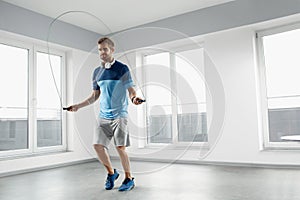 Sport Fitness Workout. Healthy Man Skipping Jump Rope Indoors.