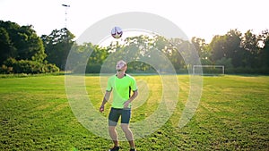 Sport, football and people - soccer player playing and juggling with ball on field