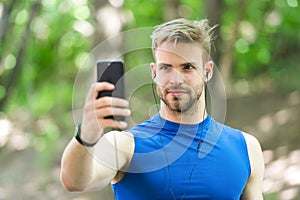 Sport gadget concept. Athlete mobile phone set up playlist before runnig. Man athlete busy face setting up smartphone photo
