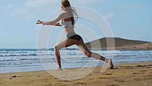 Sport girl on a beach doing lunges exercises. Concept of of a healthy lifestyle
