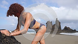 Sport girl on a beach doing lunges exercises. Concept of of a healthy lifestyle.