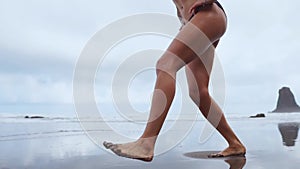 Sport girl on a beach doing lunges exercises. Concept of of a healthy lifestyle.