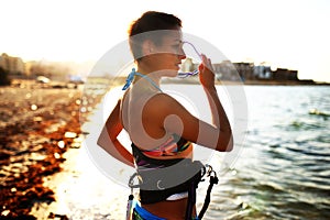 Sport girl in bikini on the beach near the sea, sunset time, golden hour light, watersport lifestyle