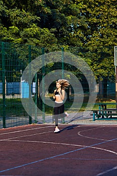 Sport girl. The girl is doing fitness exercises. Beautiful young sports woman doing exercises. A woman is training on a sports fie