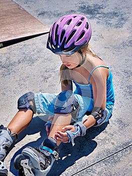 Sport girl with injury near her skateboard outdoor.