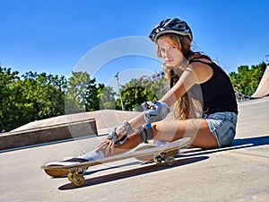 Sport girl with injury near her skateboard outdoor.