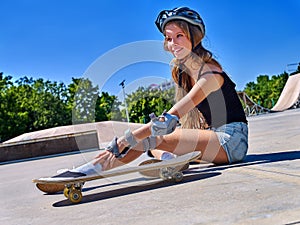 Sport girl with injury near her skateboard outdoor.