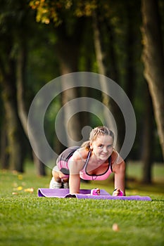 Sport girl making exercises outdoors.