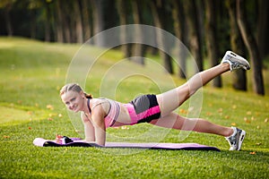 Sport girl making exercises outdoors.