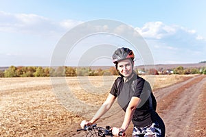 Sport girl on a mountain bike in the field side view
