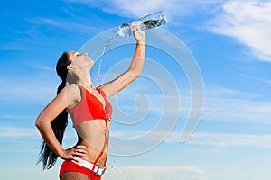 Sport girl in red uniform with a bottle of water