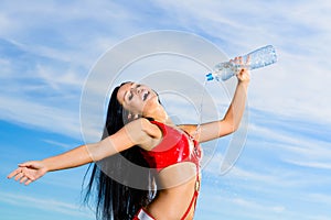 Sport girl in red uniform with a bottle of water