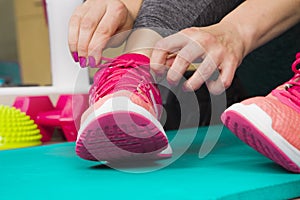 sport girl tying her shoes,Female runner tying her shoes preparing for a run,fitness exercise in gym