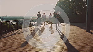 Sport girls on the background of the big city. Athletic young women doing morning exercises.