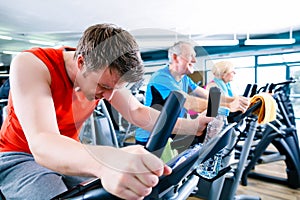 Sport in the gym - people spinning of fitness bikes