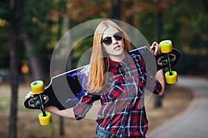 Sport happy girl posing in summer with skateboard. Stylish lucky hipster woman with colorful longboard in sunset in