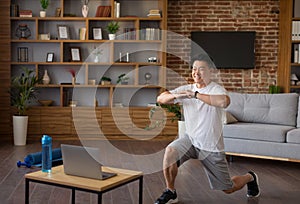 Sport and healthy lifestyle concept. Active asian man watching training tutorial on laptop and doing forward lunges