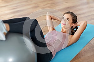 Happy woman exercising on fitness ball at home
