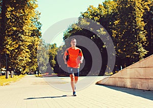 Sport and healthy lifestyle - fitness young man running in the city park, male runner working outdoors