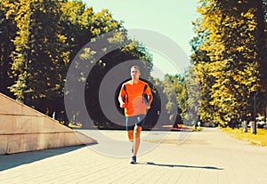 Sport and healthy lifestyle - fitness young man running in the city park, male runner working outdoors