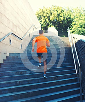 Sport and healthy lifestyle - fitness young man running in the city park, male runner working on the steps of stairs