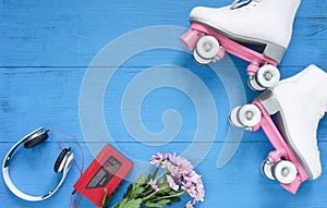 Sport, healthy lifestyle, roller skating background. White roller skates, headphones and vintage tape player. Flat lay