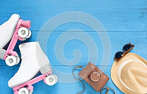 Sport, healthy lifestyle, roller skating background. White roller skates, retro camera, straw hat and retro sunglasses. Flat lay,