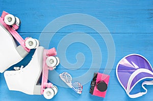 Sport, healthy lifestyle, roller skating background. White roller skates, sunglasses, pink visor hat and vintage camera. Flat lay,