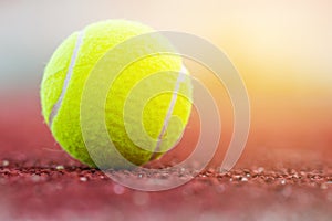 Sport Item concept : Tennis balls at red court in summer day. Tennis is racket sport that can be played individually against