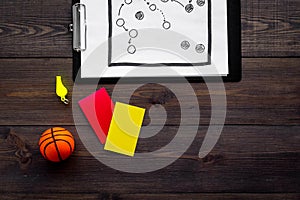 Sport judging concept. Basketball referee. Tactic plan for game, basketball ball, red and yellow cards, whistle on