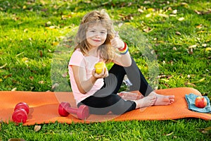 Sport kids boy. Tired teen sport boy eat apple after training in summer park. Fitness and healthy lifestyle concept