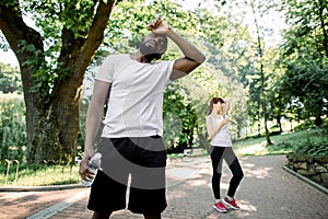 Sport lifestyle concept. Young strong African man tired after hard cardio workout, standing with water bottle. Exhausted