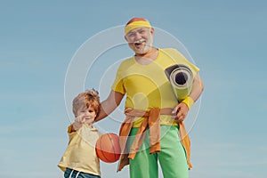Sport for little children. Senior man and child in family health club. Senior man and child exercising on blue sky