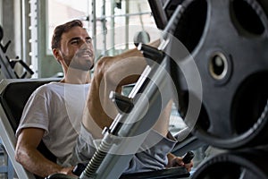sport man doing exercises with leg press machine in fitness gym . workout . training
