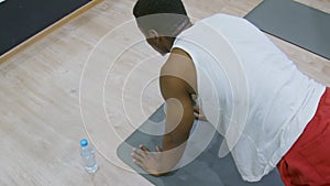 Sport man doing plank exercise, fitness workout at gym. Black male athlete with fit body exercising on yoga mat