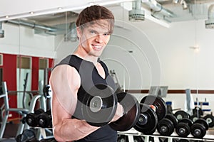 Sport - man is exercising with barbell in gym