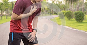 Sport man having heart attack or chest pain after running workout at park. Sport and Health care concept
