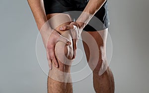 Sport man injured when exercising or running holding his knee in pain